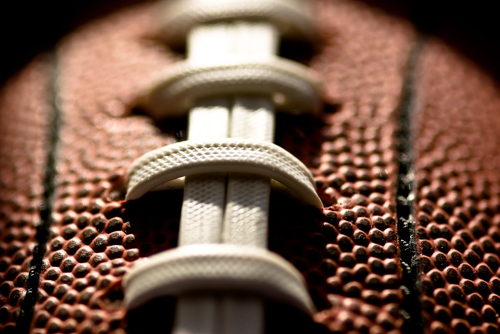 Close-up of the pebbled leather grain and laces of an American football